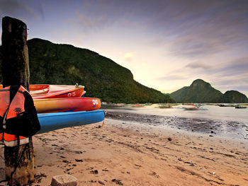 Boats on beach against mountain range