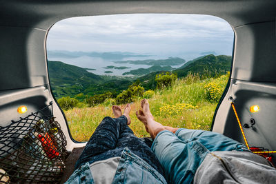 Low section of man relaxing in car