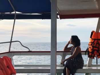 Woman looking at sea against sky