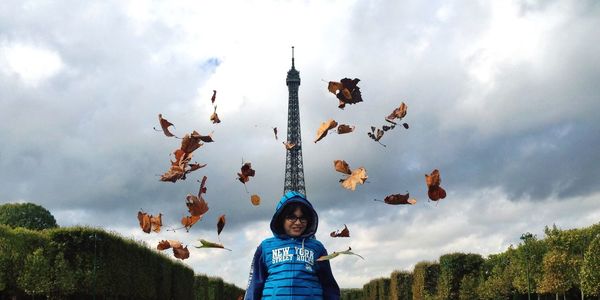 Low angle view of person standing against cloudy sky