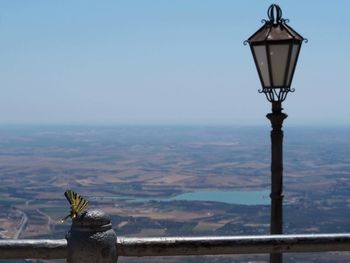 Street light by mountains against clear sky