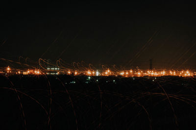 Illuminated city against sky at night