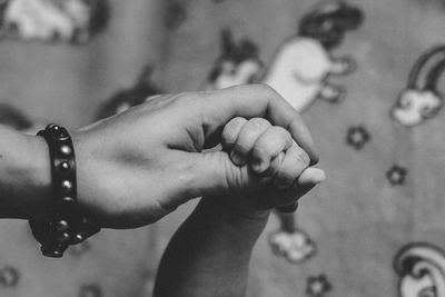 Cropped hand of woman holding baby hand