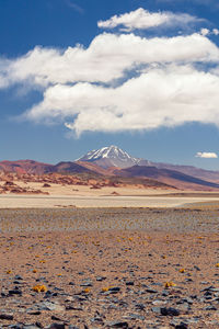 Scenic view of desert against cloudy sky