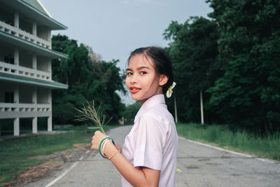 Portrait of teenage girl standing against plants