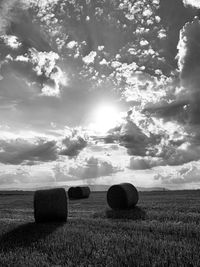 Hay bales on field against sky