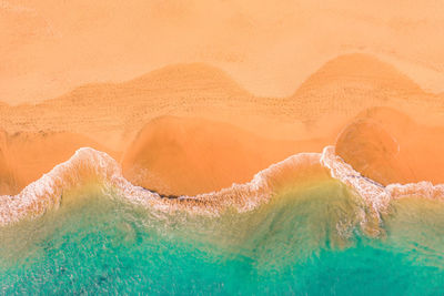 Aerial view of atlantic ocean coast with crystal clear turquoise water, waves rolling into the shore