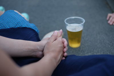 Low section of woman with alcohol in drinking glass