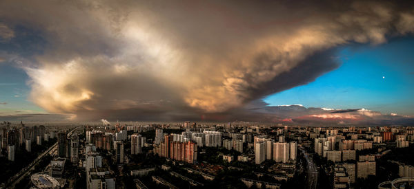 Aerial view of cityscape against storm clouds
