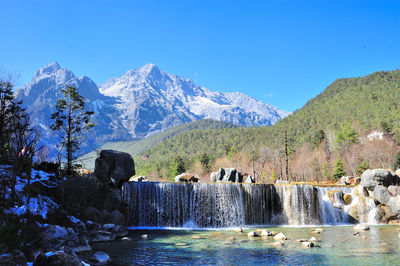 Scenic view of snowcapped mountains against blue sky