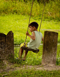 Full length of young woman swinging at park