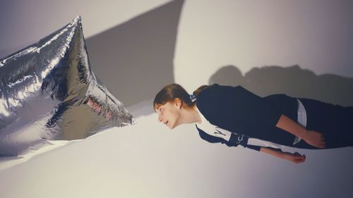 Side view of woman lying on mountain against sky