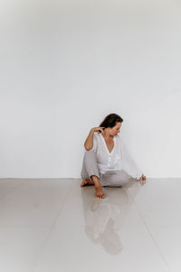 Young woman sitting on hardwood floor