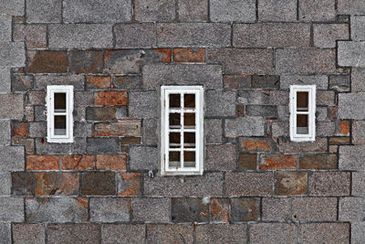 Windows amidst brick wall