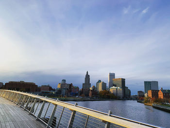 Modern buildings by river against sky in city in providence rhode island