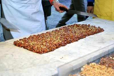 Midsection of man preparing food at market