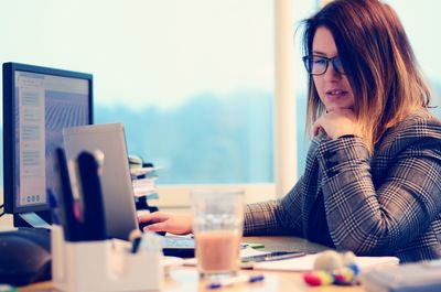 Businesswoman using laptop on desk in office