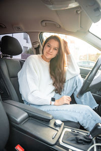 Young woman sitting in car