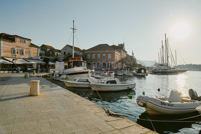 Boats moored at harbor in city against clear sky