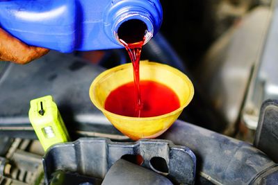 Close-up of hand pouring juice in glass