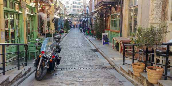 Bicycle parked on street amidst buildings in city