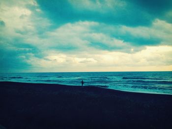 Scenic view of beach against cloudy sky