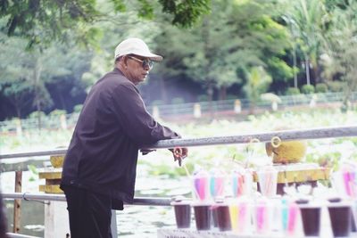 Side view of man leaning on railing