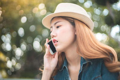 Portrait of young woman using mobile phone outdoors