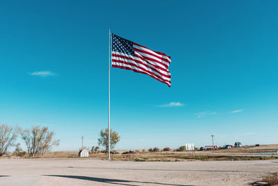 Flag on road against blue sky