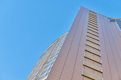 Low angle view of modern building against clear blue sky