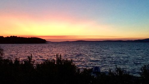 Scenic view of sea against romantic sky at sunset