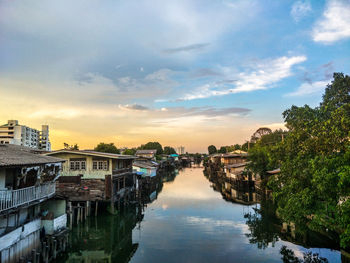 River amidst buildings in city against sky