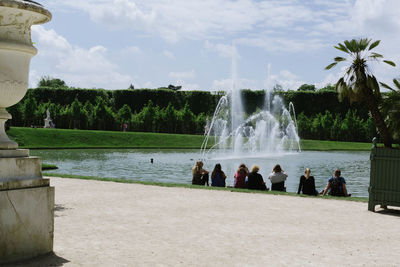 People at fountain against sky