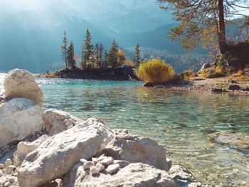Rocks by lake against sky