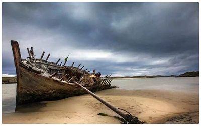 View of beach against cloudy sky