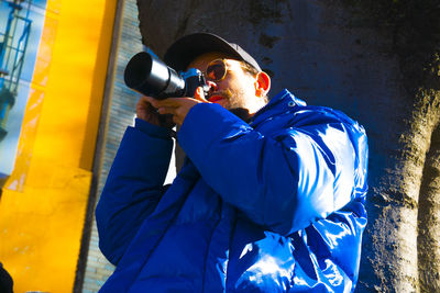 Midsection of man standing against blue wall