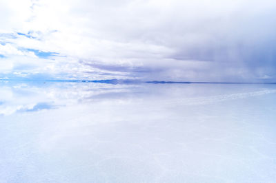 Scenic view of salar de uyuni against cloudy sky