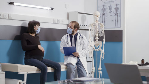 Doctor discussing with pregnant woman in clinic