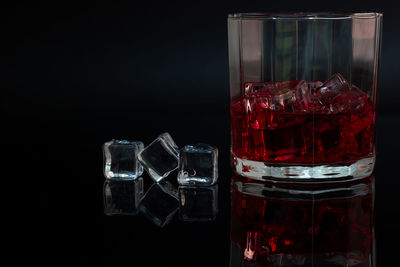 Close-up of glass on table against black background