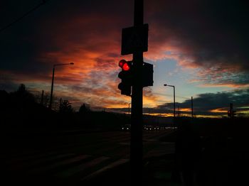 Silhouette of road sign at sunset