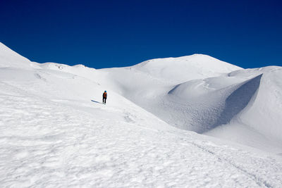 People skiing on snowcapped mountain against sky