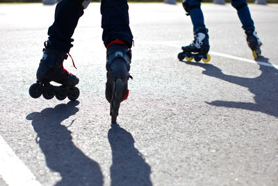 Low section of people roller skating on road