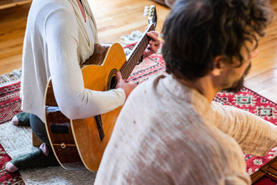 Rear view of woman playing guitar