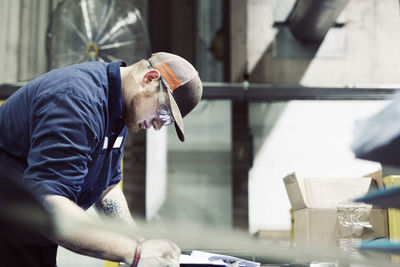 Side view of serious blue collar worker working in workshop