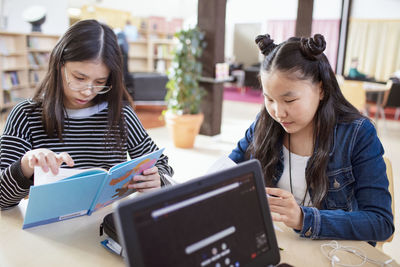 Teenage girls reading in library