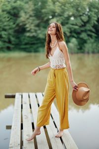 Young woman standing against lake