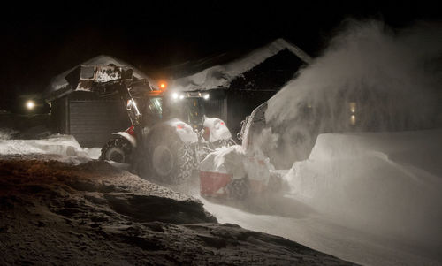 People on illuminated mountain against sky at night during winter