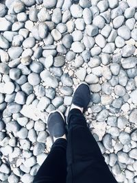 Low section of person standing on stones
