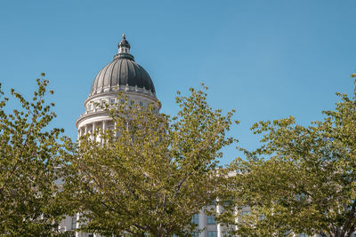 View of state capitol building and trees with clear blue sky in background