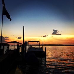 Silhouette of boat in sea during sunset